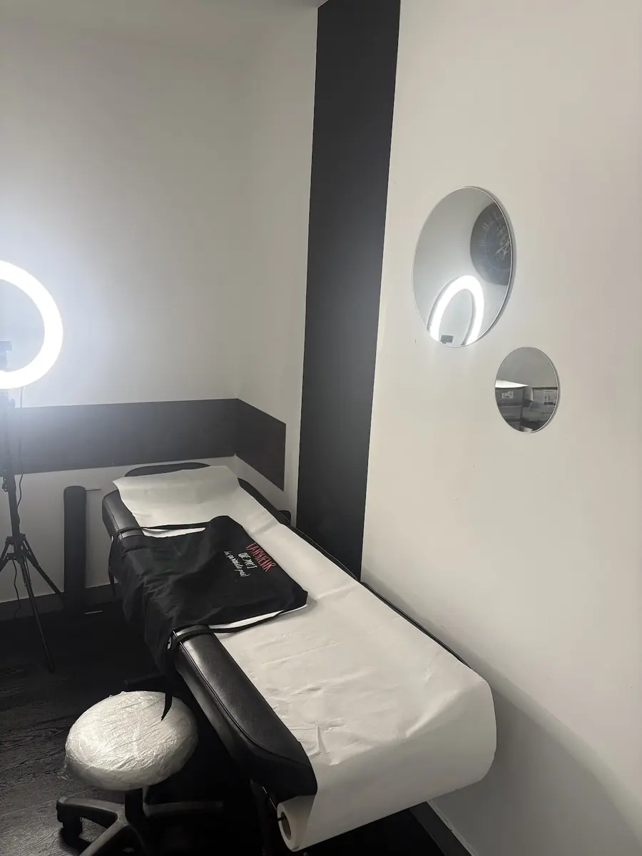 La table de tatouage du studio, protégée par un film, devant le mur anthracite.